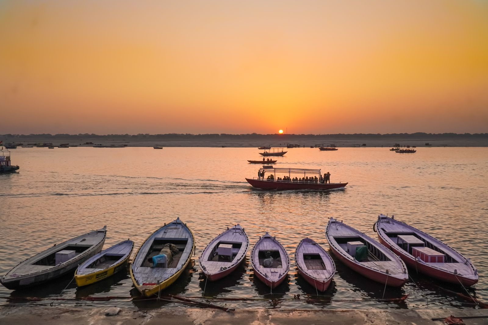 Row of rowing boats on the Ganges at Varanasi at sunset, a highlight of India river cruises