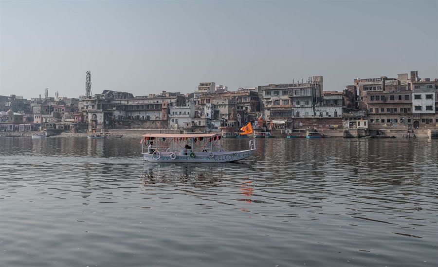 Passenger boat on the Yamuna, a tributary of the Ganges, passing the riverside buildings of Mathura