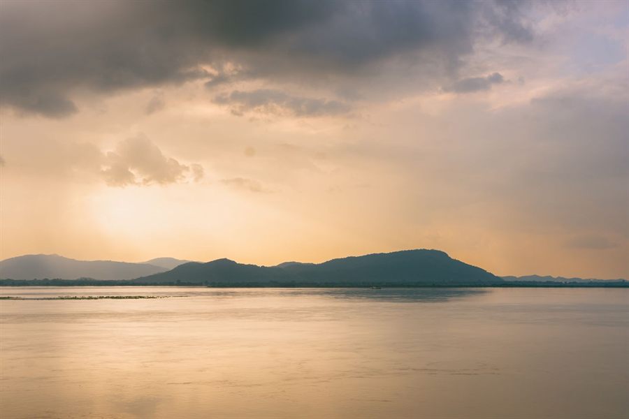 Sunset over the wide Brahmaputra River in Assam with hills on the far side