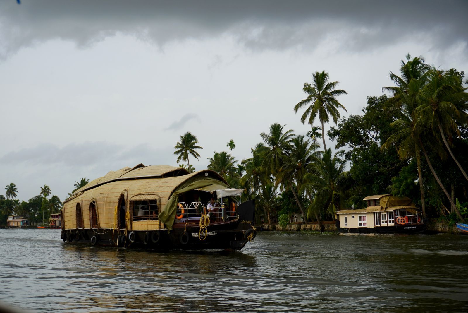Thatched Kerala houseboat on the backwaters under a stormy sky, the classic Kerala backwaters cruise