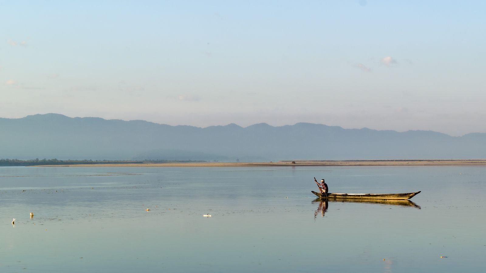 Fisherman in a small boat on the calm Brahmaputra near Biswanath Chariali, Assam, a quieter river cruise in India